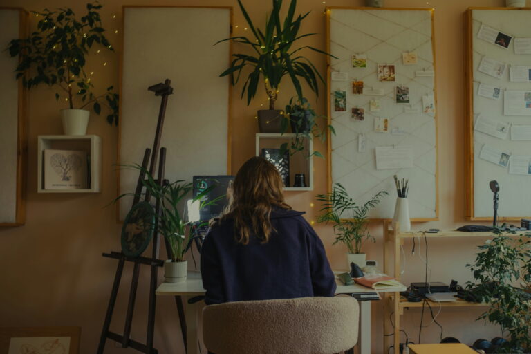 Femme qui travaille à son bureau dans un atelier lumineux rempli de plantes